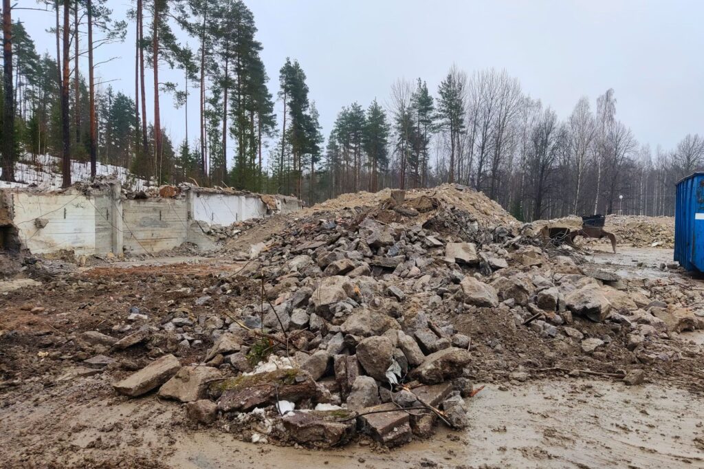 Betonijätettä kasassa mutaisella pihalla. 